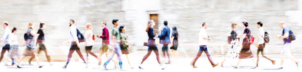 Lots of walking people, multiple exposure illustration represents modern life in the big busy city. Business people, young people, students crossing the road stock photo