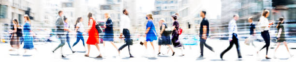 Lots of walking people, multiple exposure illustration represents modern life in the big busy city. Business people, young people, students crossing the road stock photo