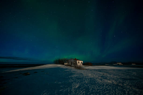 l'aurora boreale si accomoda su un piccolo cottage in islanda - dacing foto e immagini stock