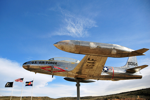 Fort Garland, Costilla County, San Luis Valley, Colorado, USA: portside view of a United States Air Force Lockheed  T-33A Shooting star on a roadside plinth, serial #57-6560, tail 138064 - Veteran’s Memorial Park, U.S. Highway 160. The T-33 was developed as a two-seat version of the Lockheed F-80C fighter-bomber. Lockheed produced 5,691 T-33s from 1948 to 1957. Canadair manufactured 656 T-33s under license as CT-133 \