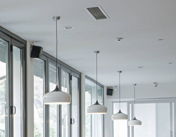 Modern pendant lamps with white lampshade near black frame folding windows