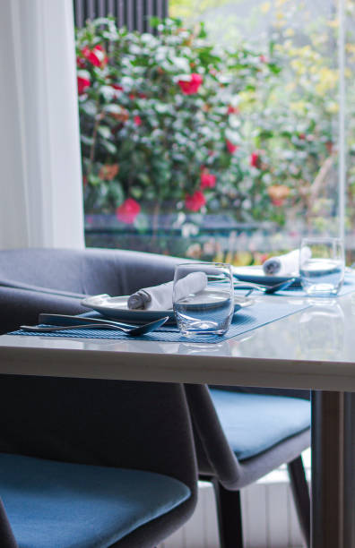 istock Drinking glass on white table with tableware near window in the garden 1354419699