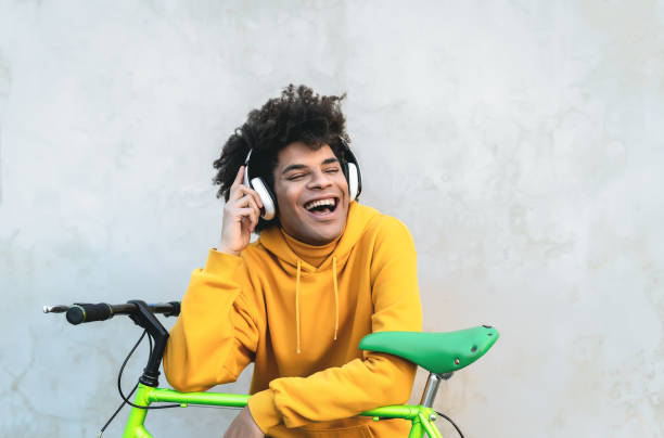 Happy Afro man listening to  playlist music with wireless headphones outdoor stock photo