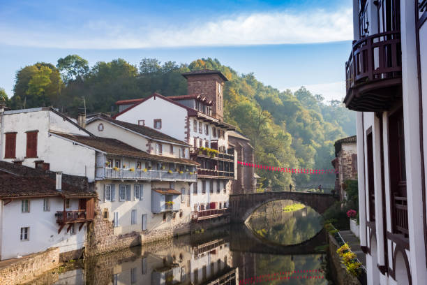 Historic bridge and tower reflecting in the Nive river in Saint-Jean-Pied-de-Port Historic bridge and tower reflecting in the Nive river in Saint-Jean-Pied-de-Port, France saint jean pied de port stock pictures, royalty-free photos & images