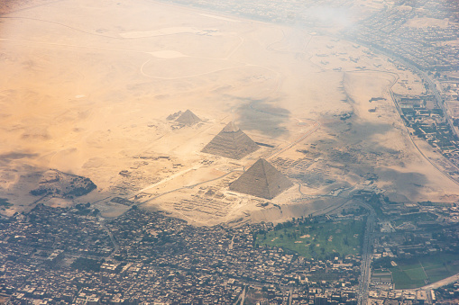 The Giza pyramid complex, also called the Giza Necropolis viewed from airplane window. Khufu, Khafre, Menkaure and Sphinx are visible.