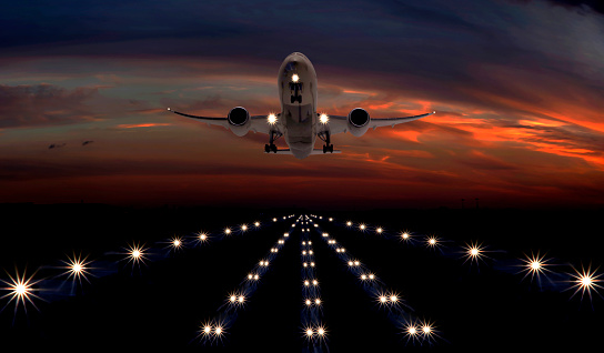 A passenger plane takes off from the night airport runway