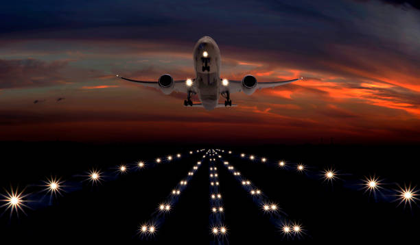 A passenger plane takes off from the night airport runway stock photo