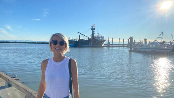 istock Senior woman standing on pier 1354424934