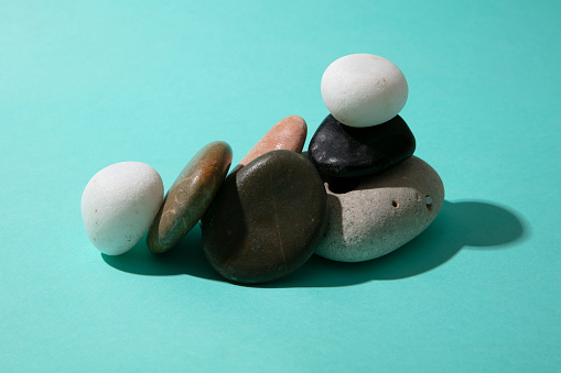 Pebbles and rocks on mint paper  background. Flat-lay, top view. Copy space for your text.Happiness