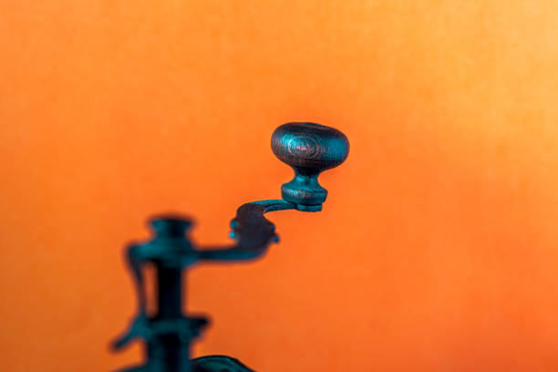 beautiful handle of the old coffee grinder on an orange background
