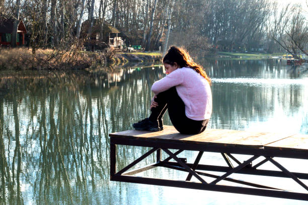 Girl sitting on the dock alone in depression