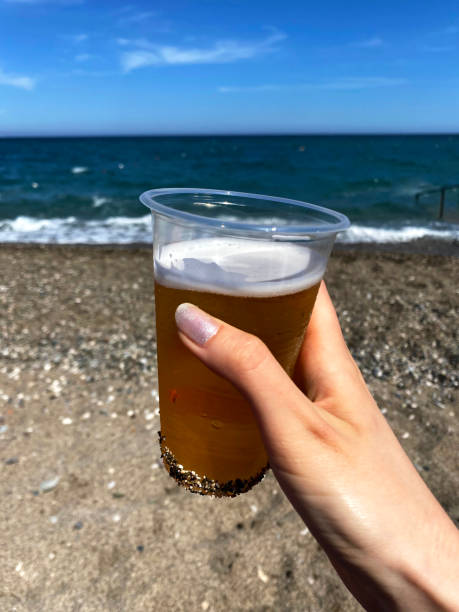 istock A woman holding beer on the beach 1354437125
