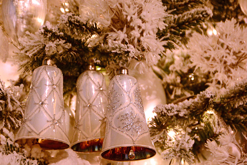 Christmas indoors: single christmas bell ornament(mass product) hanging in a christmas tree.
