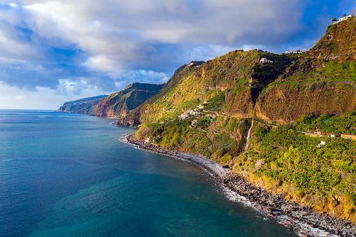 Aerial view of Cascata dos Anjos Waterfall and an old road between Ponta do Sol and Jardim do Mar with scenic coastline of Madeira island, Portugal
