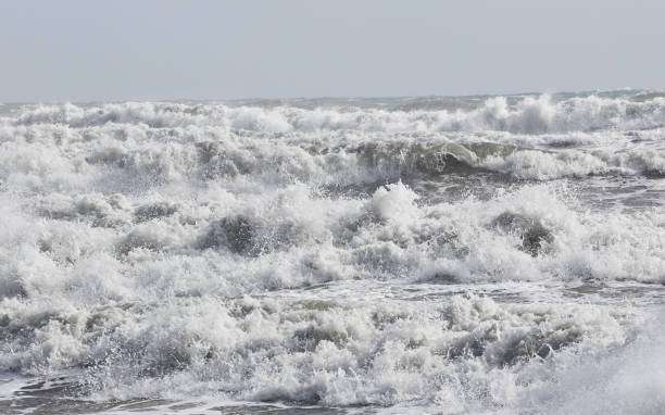 istock big waves breaking on the shore, with white foam 1354447342
