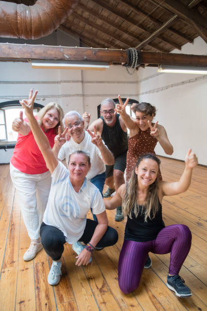 istock Happy senior dance group showing peace sign with their teacher 1354447429