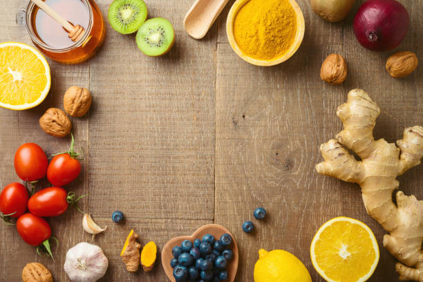 istock Frame background with immunity boosters fruits and vegetables on wooden table 1354448333