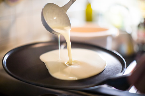 Close-up of Pouring Pancake Batter on Frying Pan.