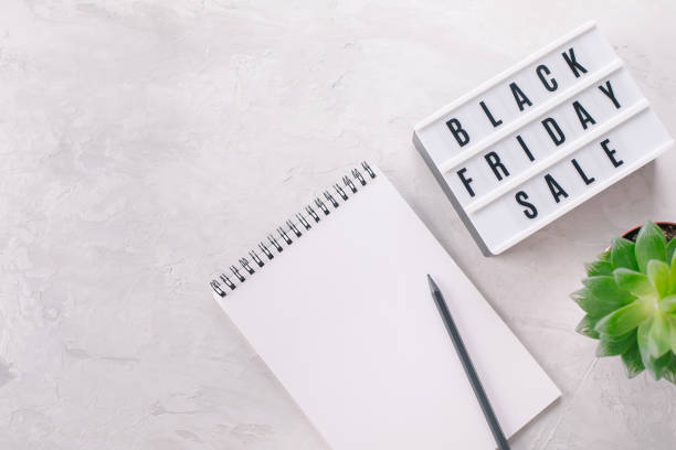 istock Black friday sale written on lightbox, plant, notebook with place for text, flat lay, copy space 1354455851