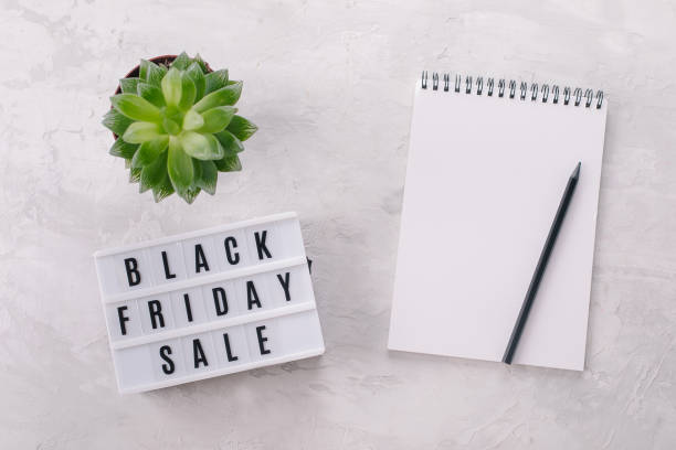 istock Black friday sale written on lightbox, plant, notebook with place for text, flat lay, copy space 1354455863