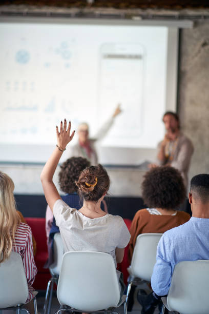 istock A young woman is asking a question during a presentation at conference room. Employees, office, work 1354457177