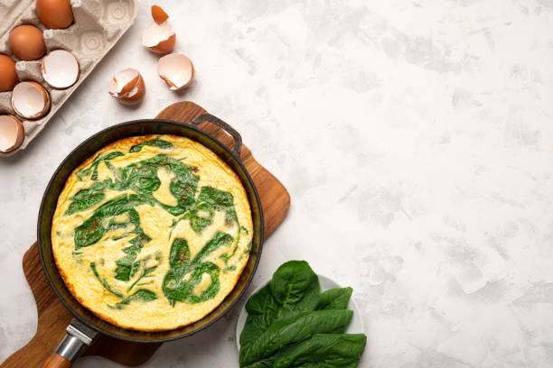 istock Frying pan SPINACH FRITTATA top view and main ingredients with copy space 1354458216