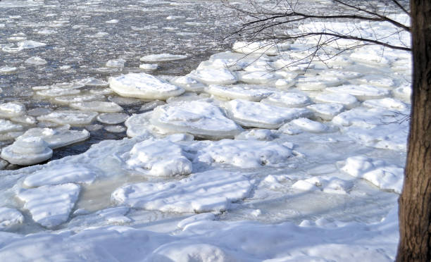 Snowy and half frozen river on a cold winter day stock photo