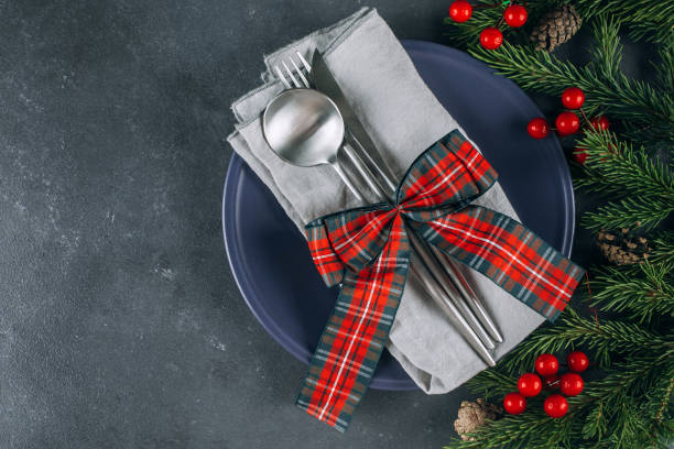istock Christmas table setting on blue table. Blue plate and silver utensils. Festive holiday decoration 1354458606