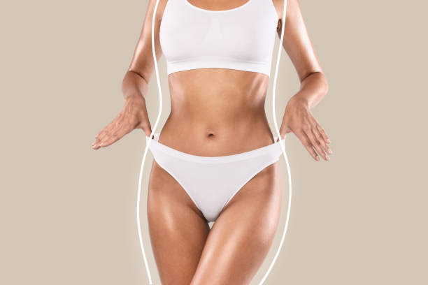 블루 스튜디오 배경에서 고립 된 포즈를 취하는 인식 할 수없는 여성 - flat stomach 뉴스 사진 이미지