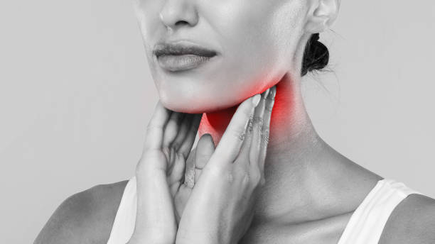 istock Young woman suffering from sore throat, gray studio 1354463329