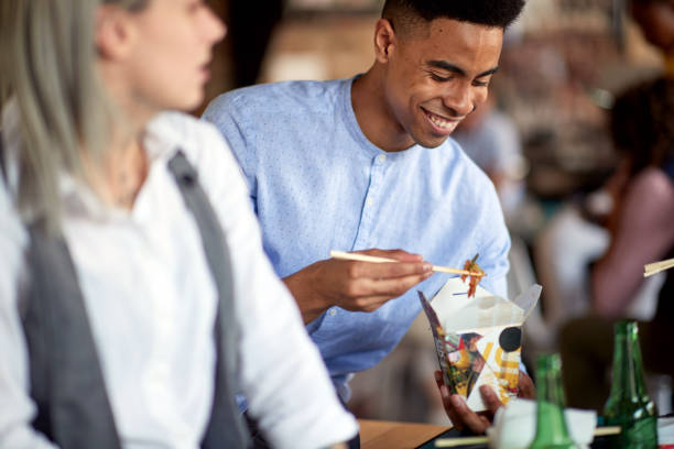 istock A young man is enjoying a meal during a lunch break in the office 1354463440