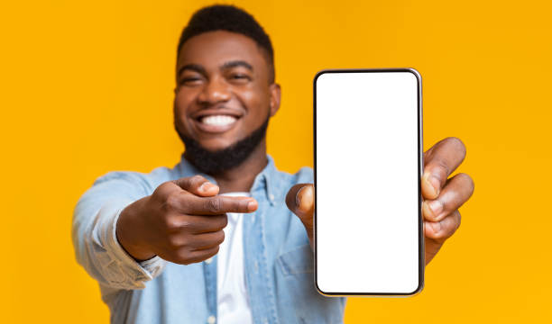 istock Smiling african american man pointing at cellphone with blank screen 1354464096