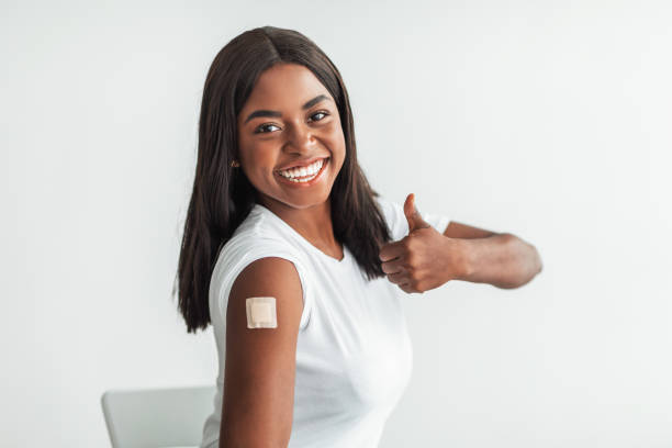 istock Black Vaccinated Female Showing Shoulder With Patch And Thumbs Up 1354465218