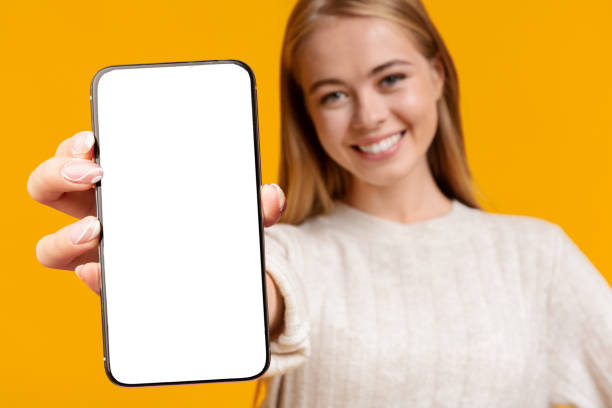 istock Closeup of cellphone with empty screen in young lady hand 1354465272