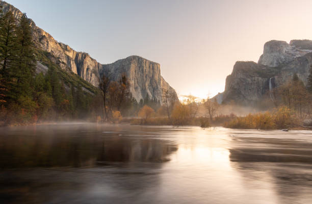 early sunrise view of el capital reflected on river with low clouds moving through the valley - yosemite falls bildbanksfoton och bilder