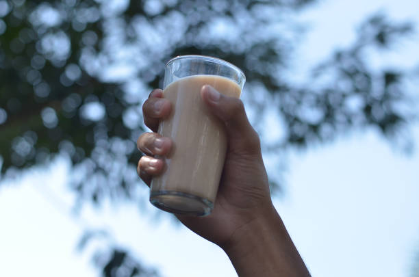 istock Man hand holding Iced Milk Tea in the glass refreshing look with blurred background. selective focus 1354467208