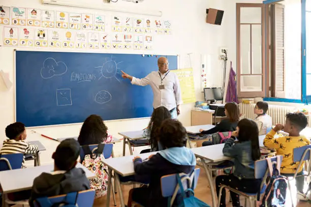 Photo of Elementary Teacher Pointing to Illustrations of Emotions