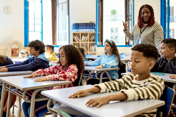 istock Mature Female Teacher Directing Students During Quiet Time 1354472019