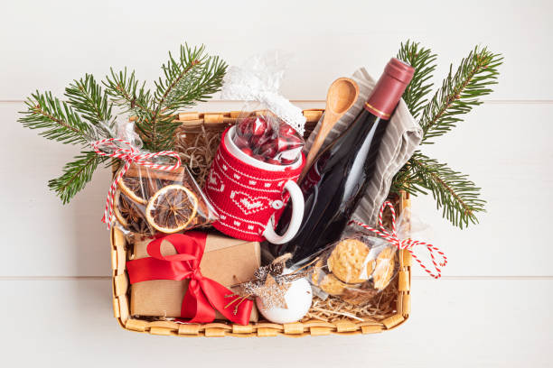 refinada cesta de regalo de navidad para entusiastas culinarios con botella de vino e ingredientes de vino caliente - gift orange green package fotografías e imágenes de stock