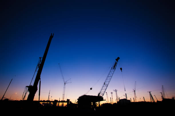 Photo shot of Landscape Silhouettes of Cranes at Construction Site at Sunset