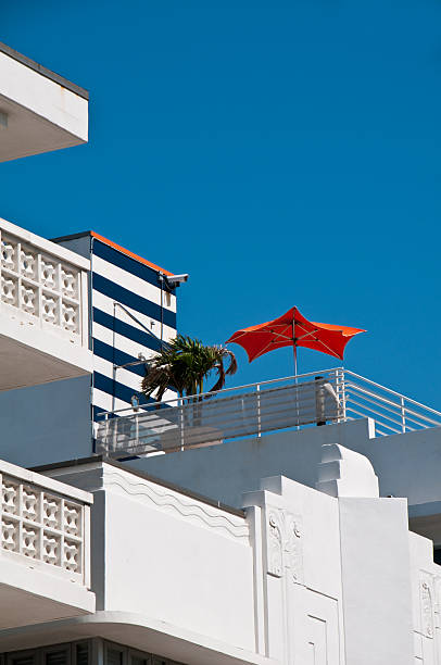 Lonely Orange Umbrella A lone orange umbrella atop an Art Deco building on Miami;s South Beach 1 hotel south beach stock pictures, royalty-free photos & images