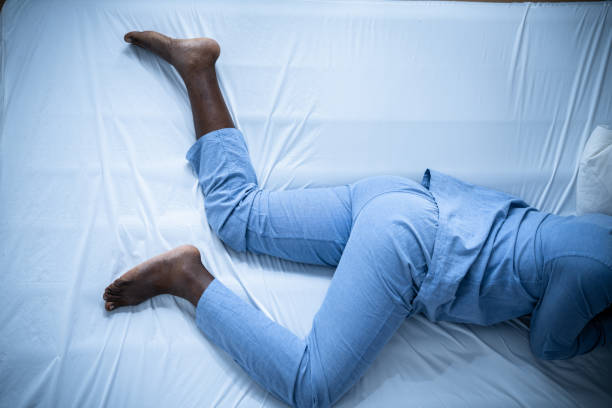 African American Man With RLS - Restless Legs Syndrome African American Man With RLS - Restless Legs Syndrome. Sleeping In Bed leg stock pictures, royalty-free photos & images