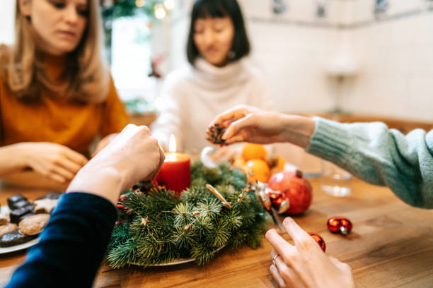 friends sitting at christmas table with advent wreath