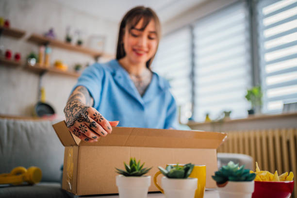 istock Woman unpacking cardboard delivery package 1354485718