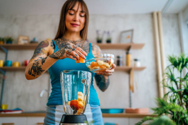 istock Woman preparing fresh fruit smoothie 1354487547