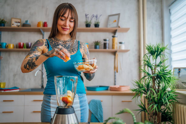 istock Woman preparing fresh fruit smoothie 1354488231