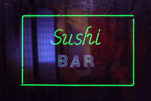 Vintage Neon Sushi Bar Sign in Wet Window