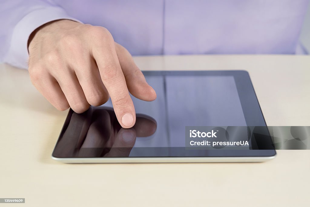 Businessman Touching On Tablet PC Closeup shot of businessman hands are touching on digital tablet pc. Shallow depth of field on finger. Adult Stock Photo