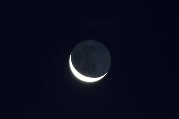 istock Grey light of waning crescent, moon on dark black sky 1354496805