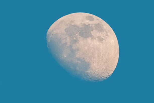 istock Waxing gibbous moon on blue sky 1354496811